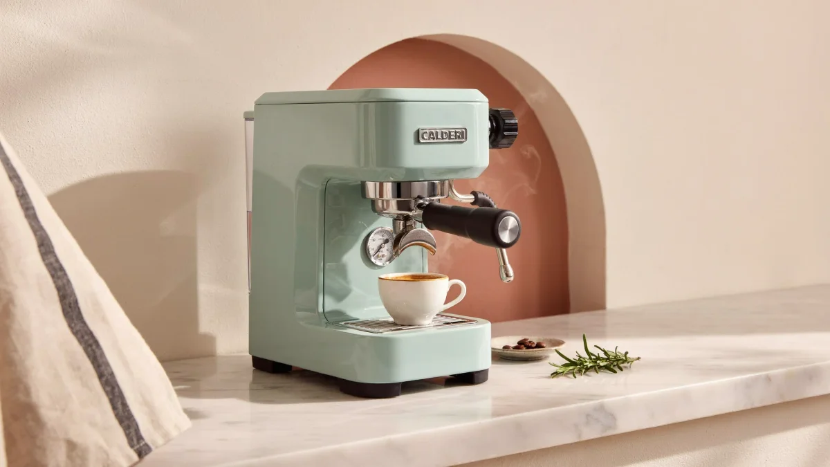 Mint-green espresso machine in a terracotta niche