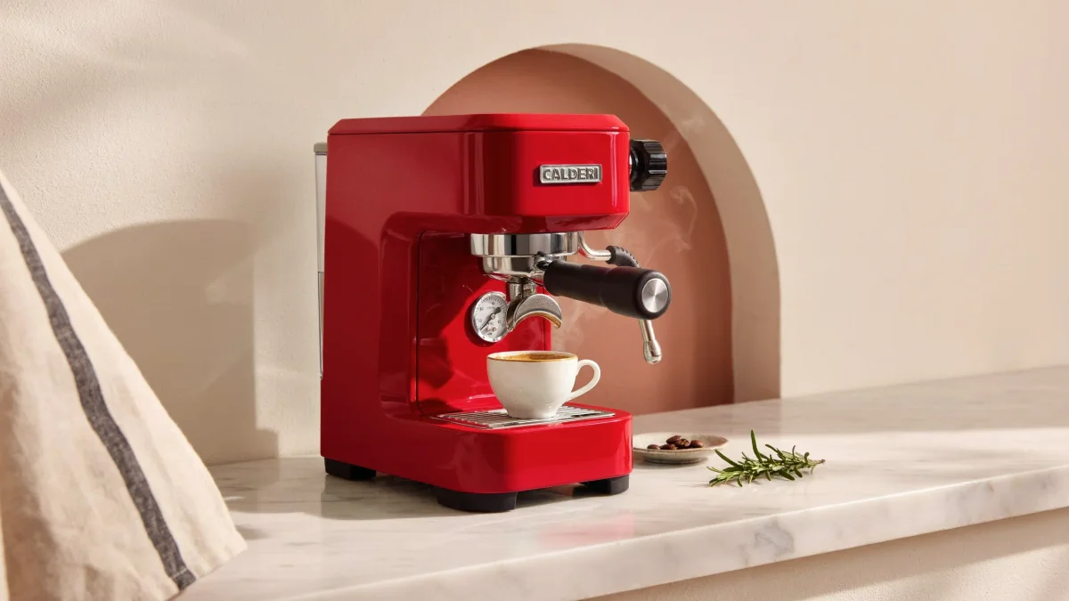 Cherry-red espresso machine in a terracotta niche